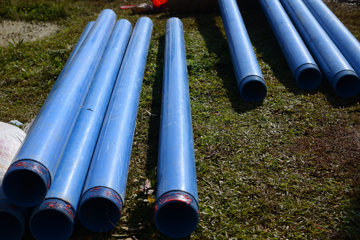 Des tubes filtrants bleus sont posés sur la pelouse